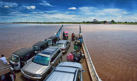 Phnom Penh, Cambodia -cars, motorbikes and people on a ferry crossing the Mekong riverのeditorial素材