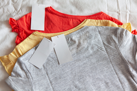 Three new t-shirt in few colours with clean label on white background. Concept shopping, summer sales, discounts, organic cotton clothes, recycled clothingの写真素材