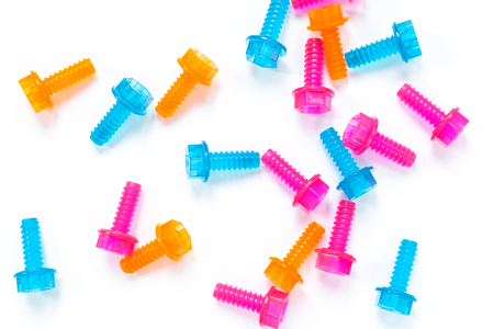 Colored neon translucent plastic toy bolts on white background. Flat lay. Concept World Dad's Day,...