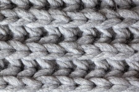Knitted woolen textured surface, macro. Soft grey merino wool pattern backdrop, closeup. Autumn and winter flat lay. Scandinavian minimal style.の写真素材