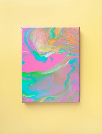 Painting in bright pastel colors on wall using liquid fluid art trendy technique. Central composition. View opposite or from above. Flat lay. Close-up. Concept contemporary art accessible to everyoneの写真素材