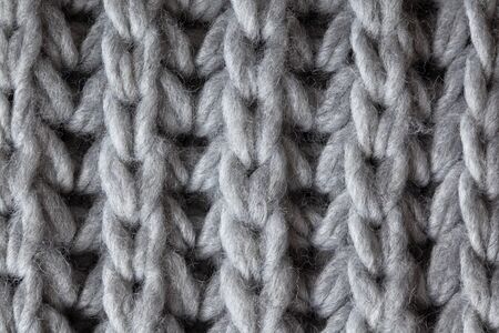 Knitted woolen textured surface, macro. Soft grey merino wool pattern backdrop, closeup. Autumn and...