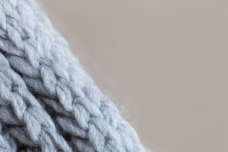 Knitted woolen textured surface on beige background. Macro. Soft grey merino wool pattern backdrop, closeup. Autumn and winter flat lay. Scandinavian minimal style. Horizontalの写真素材