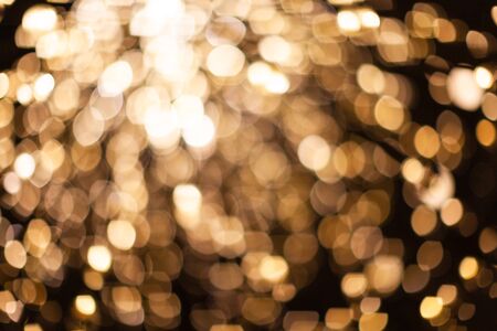 Abstract blurred background with numerous bright gold festive bokeh. Texture with copy space for text. Celebration, holidays concept. Horizontalの写真素材