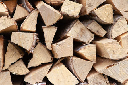 Background from stack of firewood from birch tree, for heating house, stacked in backyard, uncut wood, birch. Concept eco-friendly home heating during cold season. Overall plan. Horizontal format.の写真素材