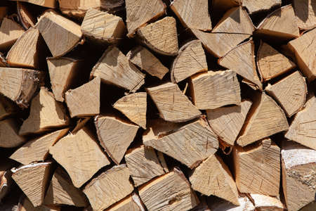 Background from stack of firewood from birch tree, for heating house, stacked in backyard, uncut wood, birch. Concept eco-friendly home heating during cold season. Overall plan. Horizontal format.の写真素材