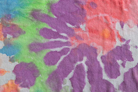 Pastel tie dye, a handmade pattern on a cotton t-shirt. Close-up, top view. DIY concept, handicrafts, original everyday clothes, fabric dyeing techniques. Flat lay, horizontal. Abstract background.の写真素材