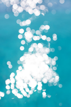 View of blurry surface of turquoise water with glare in swimming pool, sea, lake, or ocean, summer mood background. Concept rest, travel, wellness, spa procedures, season of vacations, sport.の写真素材