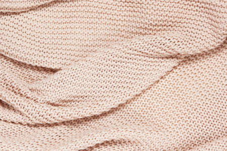 Textured surface of knitted cotton wave plaid, top view, closeup. Soft dusty pink pastel wool...