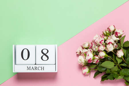Perpetual calendar with date March 8, bouquet of small roses on two-color background pink and green. Flat lay. Top view. International Happy Women's Day celebration concept. Close-up, copy space.の写真素材