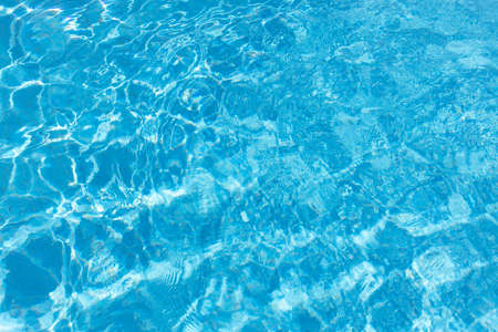 View of surface of turquoise water in swimming pool, summer background. Gradient of color with waves. Concept rest, travel, wellness, spa procedures, season of vacations, sport.の写真素材