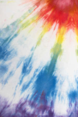 Pastel tie dye, a handmade pattern on a cotton t-shirt. Close-up, top view. DIY concept, handicrafts, original everyday clothes, fabric dyeing techniques. Flat lay, Vertical. Abstract background.の写真素材