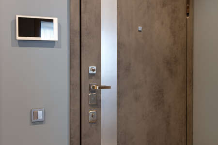Shabby design entrance door in a modern apartment hallway, video intercom device on the wall....
