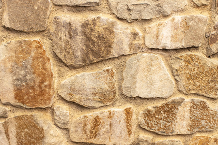 Stone fence or wall, close-up, side view. Concept details of the exterior of the house, decor options, protection, safety. Background, texture with place for text, copy space. Horizontal.の写真素材