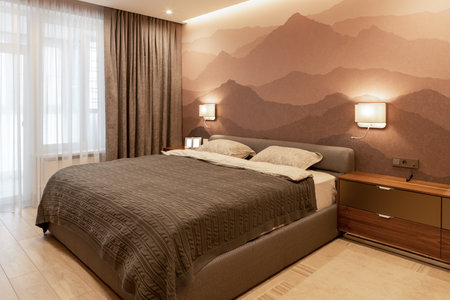 Modern bedroom in the apartment, in neutral earthy tones. Double bed with a soft textile headboard. Small photographs on the bedside table, mock-up. Minimalism style, Scandinavian. Horizontal.の写真素材