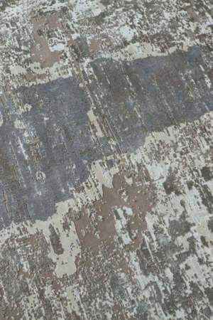 Background from a stylish carpet in neutral gray-beige tones with fading and artificial antiquity effect. Concept details of a fashionable interior, carpets. Abstract texture. Vertical.の写真素材