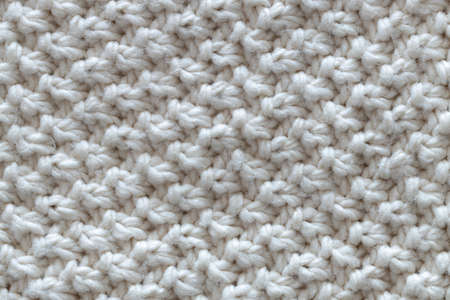 Background from beautiful, knitted background, nodules pattern. Concept handicrafts, DIY, leisure, fashionable warm clothes, hobbies. Top view, macro, close-up, flat lay. Horizontal.の写真素材