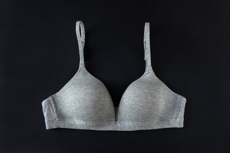 Gray organic or recycled cotton bra on black background, top view, copy space, flat lay. Concept of femininity, comfort, home clothes, underwear, natural textile, minimal style. Horizontal.の写真素材