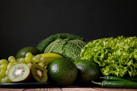 Fresh raw fruits and vegetables compositions on wooden table dark grey background. Nutritious healthy tasty delicious vegetarian vegan detox diet concept.の写真素材
