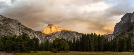 Forester valley with granite walls and Half Dome in evening sunshine against clouds in Yosemite national park in USA at autumn, Americaの写真素材