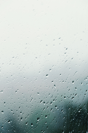 Dirty glass of raindrops on blurred backgroundの写真素材