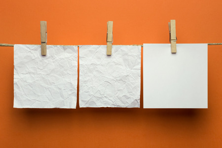 Cards hanging on a rope with clothespins, orange backgroundの写真素材