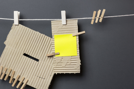 Pieces of cardboard hanging with the clothespins, grey backgroundの写真素材