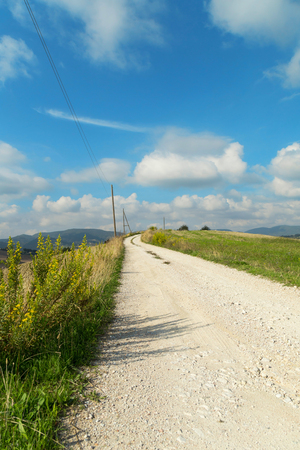 Rural landscape with country road and blue skyの写真素材