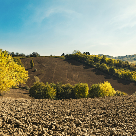 Natural landscape on a sunny day, plowed fields with blue skyの写真素材
