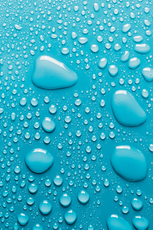 Surface with water drops, light blue backgroundの写真素材