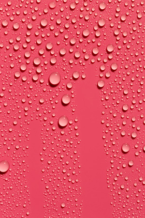 Drops of water on red color surface, abstract backgroundの写真素材