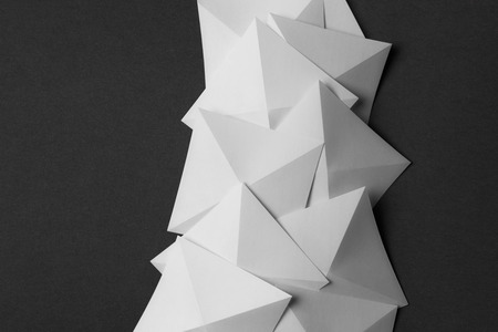 Overlapping geometric shapes of white paper, isolated on grey backgroundの写真素材