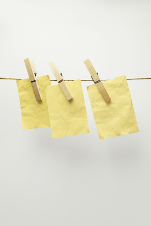 Yellow cards hanging on a clothesline with clothespin, isolated on white backgroundの写真素材