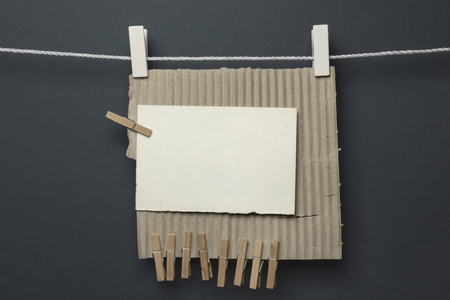 Piece of cardboard hanging with the clothespins, grey backgroundの写真素材