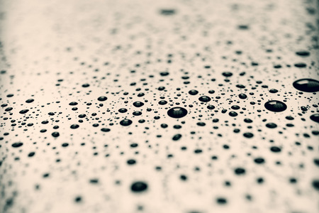 Black drops on light surface, abstract backgroundの写真素材