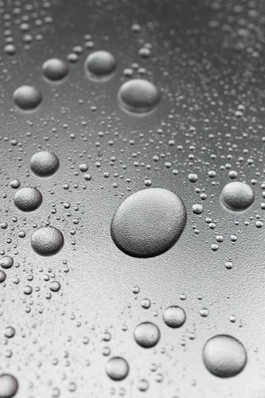 Silver drops on rough surface, abstract backgroundの写真素材