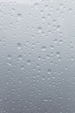 Light rain on the window glass, grainy texture on backgroundの写真素材