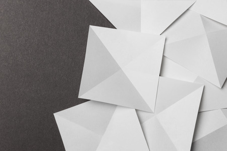 Overlapping geometric shapes of white paper; isolated on grey backgroundの写真素材