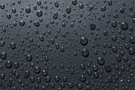 Closeup of raindrops on a gray surface, abstract backgroundの写真素材