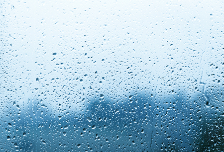 Raindrops on a window glass, on background the landscape blurredの写真素材