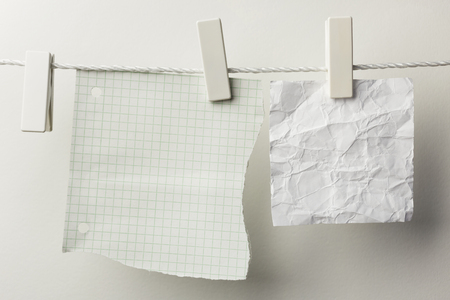 Pieces of note paper hanging with clothespins, isolated on whiteの写真素材