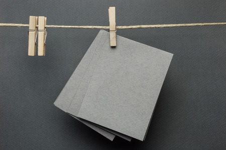 Grey card hanging on a clothesline with clothespinsの写真素材