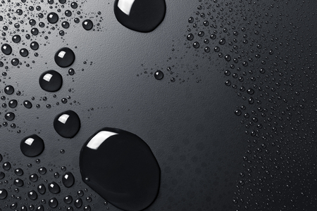 Black drops on a dark surfaceの写真素材
