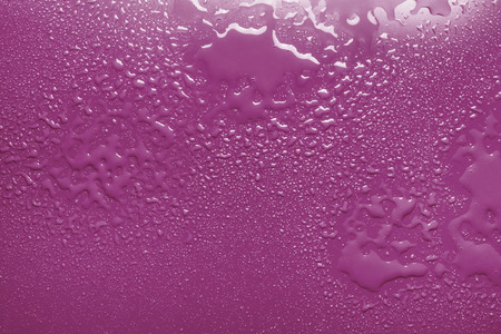 Surface with water drops, pink backgroundの写真素材