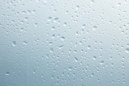 Light rain on the window glass, grainy texture on backgroundの写真素材