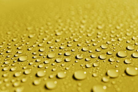 Drops of water on yellow color surface, abstract backgroundの写真素材