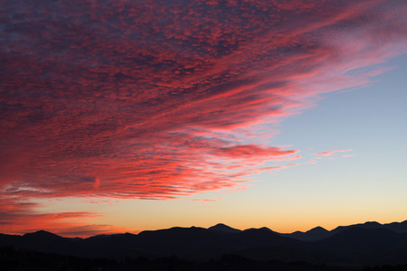 Natural scene with beautiful sky and clouds during sunset, mountains in the distanceの写真素材