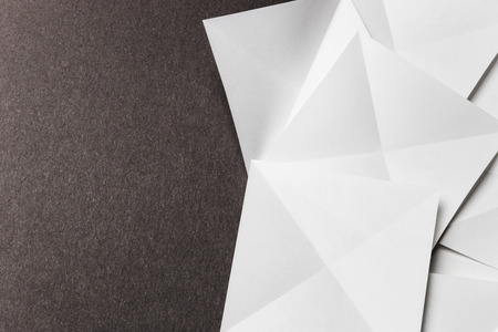 White cards folded in pyramidal shapes; isolated on grey backgroundの写真素材