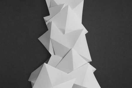 Overlapping geometric shapes of white paper, isolated on grey backgroundの写真素材