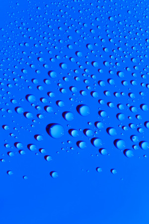 Drops of water on a blue color surface, abstract backgroundの写真素材